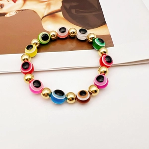 Bracciale elastico con perline Evil Eye colorate e accenti dorati su rivista di moda