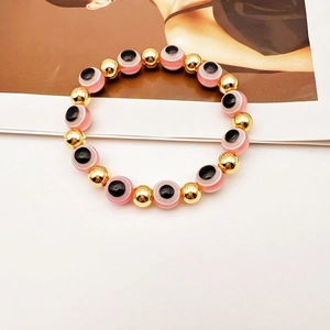 Dettaglio delle perle rosa Malocchio e perline dorate sul bracciale elastico regolabile