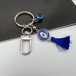 Detail of Turkish Evil Eye keychain with blue enamel pendant and dark blue silk tassel