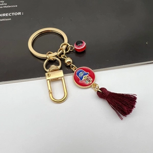 Detail of Hamsa Hand keychain with red enamel, crystal accents and deep red tassel charm