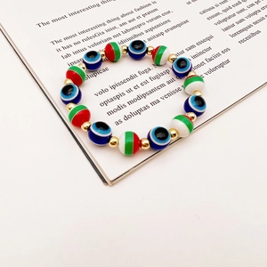 Close-up of Evil Eye Christmas beaded bracelet with Fatima palm and metallic gold spacers