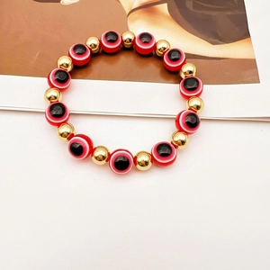 Dettaglio di perline rosse Malocchio con distanziali dorati su un bracciale elastico