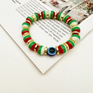 Macro shot of colorful beaded evil eye bracelet with red green white beads and gold accents