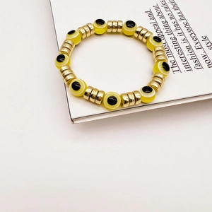 Gelbes Evil Eye Perlenarmband mit vergoldeten Trennelementen im Boho-Stil