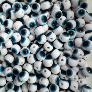 Macro shot of circular evil eye resin beads with blue white and black concentric rings