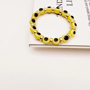 Detail of yellow translucent beads featuring the evil eye symbol and gold spacers