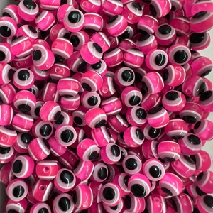 Flat lay macro of hot pink resin evil eye beads for jewelry making and beadwork
