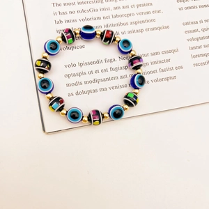 Detailed close-up of colorful evil eye beads and golden spacer beads on a stretch bracelet