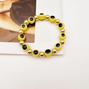 Macro di bracciale con perline Evil Eye gialle e sfere metalliche dorate lucide
