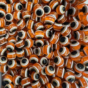 Close-up of orange evil eye glass beads for DIY necklaces and handmade bracelets