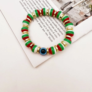 Macro detail of Christmas beaded bracelet with colorful stripes and blue evil eye charm
