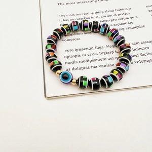 Detailed close-up of evil eye beaded bracelet with colorful patterns on white book page