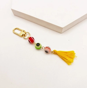 Close-up of evil eye keychain with colorful beads and a bright yellow tassel charm