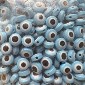 Macro detail of bulk light blue Evil Eye flat beads for DIY jewelry making and crafts