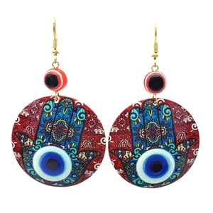 Detailansicht der böhmischen Hamsa-Hand und Evil-Eye-Muster auf runden Ohrhängern