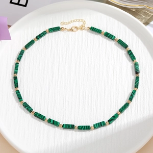 Dettaglio di collana di perle colorate con malachite verde e perline distanziatrici dorate