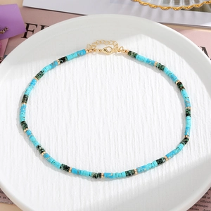 Dettaglio collana di perle in pietra colorata con perle turchesi e chiusura a moschettone