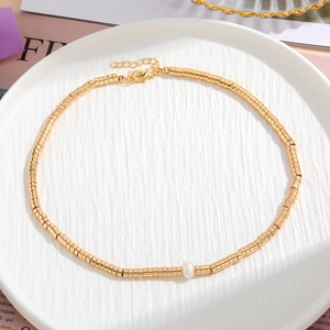 Dettaglio della collana di pietre naturali colorate con perle dorate e una perla bianca