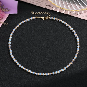Dettaglio della collana di perline con cubi di cristallo blu, grani dorati e chiusura a moschettone