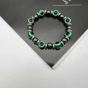 Close-up of elastic bracelet with green evil eye beads and black hematite stones