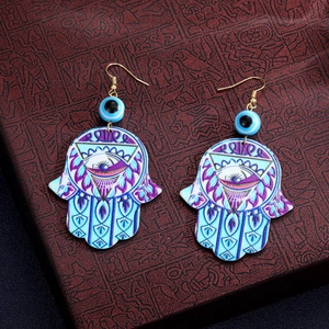 Detail der böhmischen Hamsa-Hand-Ohrringe mit Evil Eye-Perlen und lila Mustern