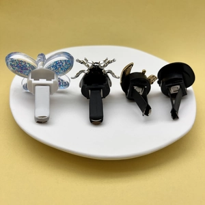 Dettaglio di quattro clip creative per bocchette auto con design a farfalla