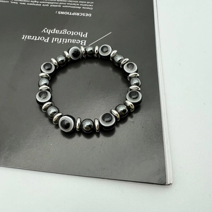Detailed close-up of hematite bead bracelet with blue Evil Eye and silver spacers