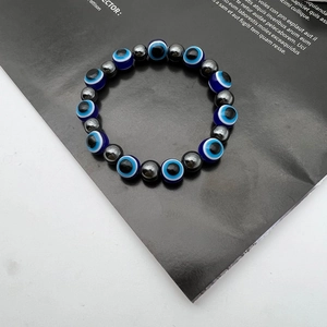 Macro view of blue evil eye beads and grey hematite stones on a beaded elastic bracelet