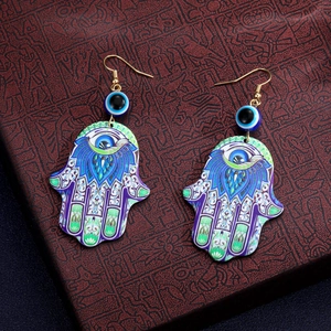 Detail von Hamsa-Hand-Ohrringen mit bösem Blick, bunten Mustern und Goldhaken