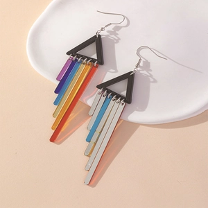 Rainbow acrylic tassel drop earrings with geometric frame and silver hooks on ceramic tray