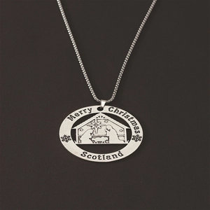 Detail of silver Merry Christmas necklace with hollow Jesus scene and snowflake engraving