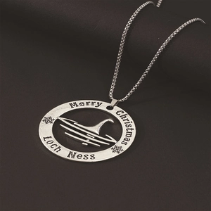 Detail of vintage silver Loch Ness Monster pendant with Merry Christmas engraving and box chain