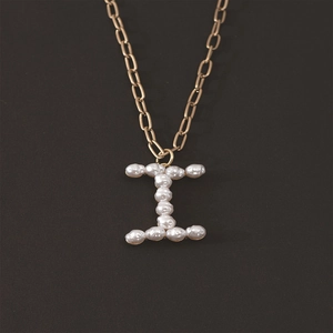 Detailed view of the letter I pendant featuring inlaid pearls on a gold rectangular chain link