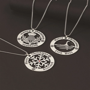 Detailed engraving of Scottish thistle and Loch Ness Monster on silver festive pendants