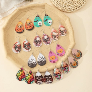 Detail of Halloween drop earrings featuring pumpkin, skull, and bat motifs on faux leather