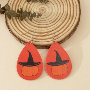 Faux leather leaf earrings with Halloween pumpkin and wizard hat patterns on wood tray