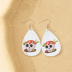 Primer plano detallado de aretes de cuero en forma de gota con diseño de calavera y hojas