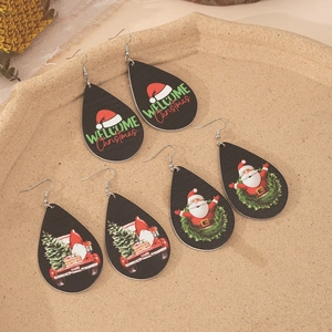 Three pairs of teardrop wooden Christmas earrings with Santa and truck festive patterns