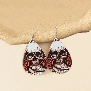 Close-up of teardrop faux leather earrings with gothic skull and red rose pattern
