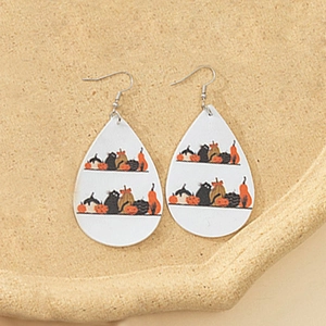 Detalle de pendientes de gota de cuero con estampados de Halloween de gato negro y calabaza