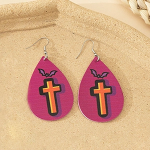 Macro detail of tear-drop faux leather earrings with purple bats and cross patterns