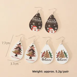 Three pairs of wooden teardrop earrings with Christmas patterns and holiday greetings