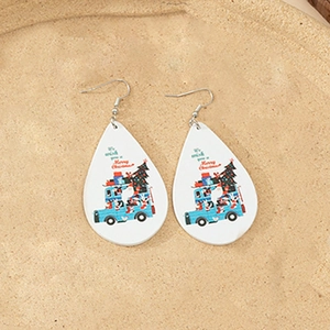 Detail of teardrop wood earrings with festive blue bus and Christmas tree graphics