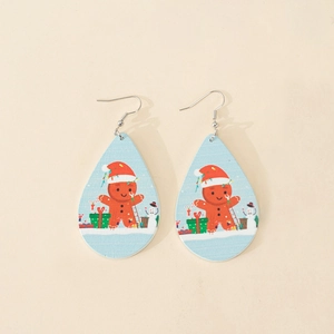 Macro view of teardrop wooden earrings featuring Christmas gingerbread man and snowman