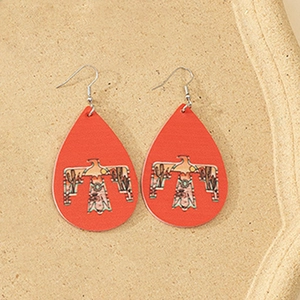 Macro shot of red faux leather teardrop earrings featuring ethnic thunderbird patterns
