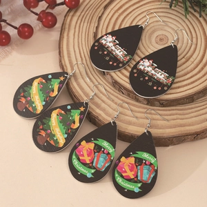 Three pairs of Christmas teardrop earrings featuring Santa and tree designs on wooden base