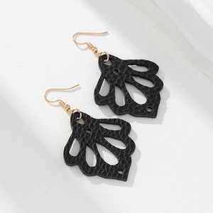 Détail des boucles d'oreilles en simili cuir noir avec motif évidé en forme d'éventail