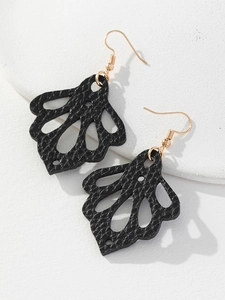 Détail de boucles d'oreilles en cuir noir en forme de pétale avec crochets dorés