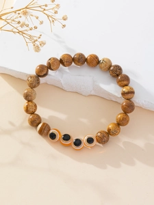 Detail of handmade beaded bracelet featuring blue evil eye beads and natural picture jasper stones