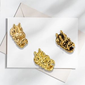 Detailed macro view of vintage gold-plated dragon head beads for DIY jewelry making
